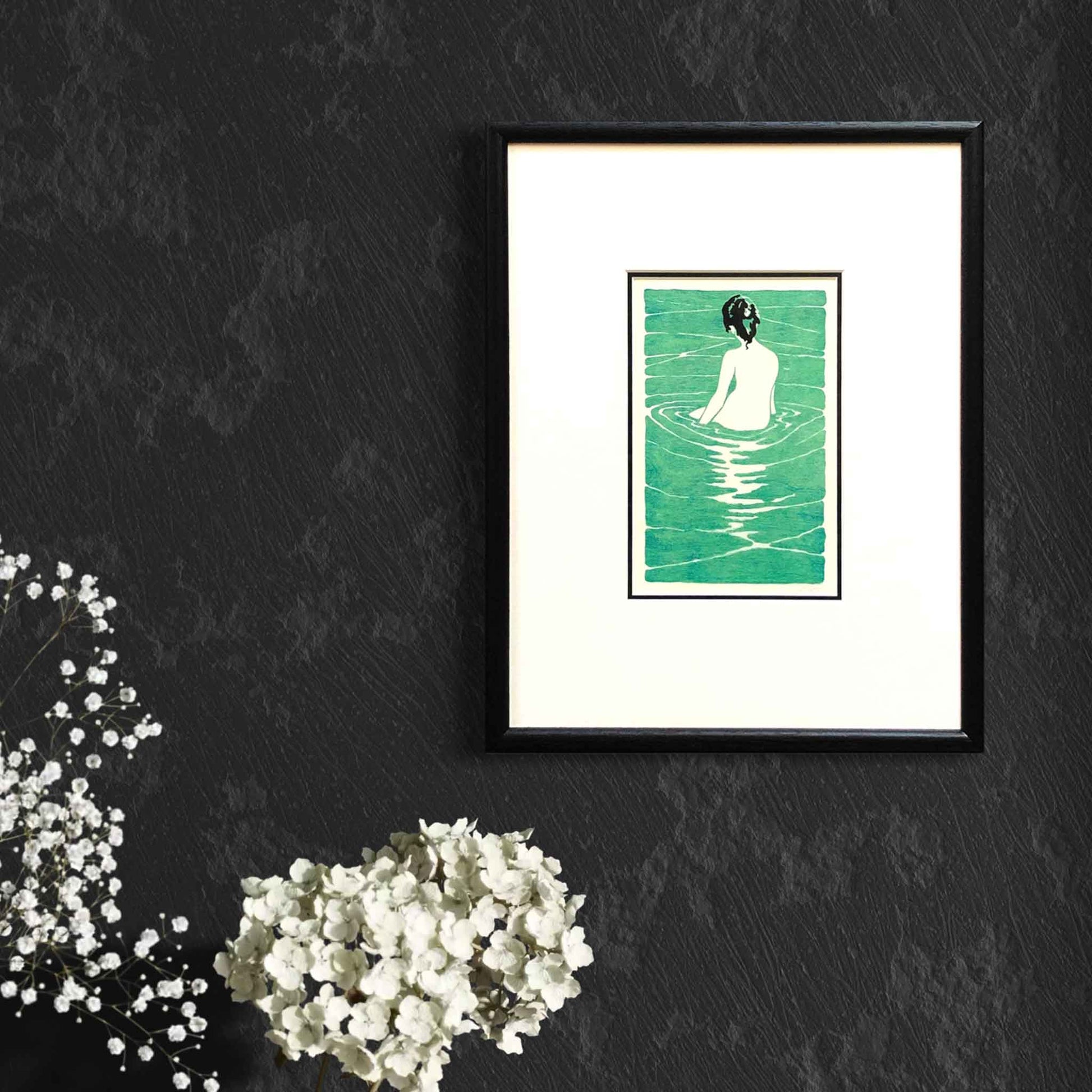 At the Hot Spring, after Ichijo Narumi — framed woodblock print by artist Claire Cameron-Smith, shown on a dark wall for scale.