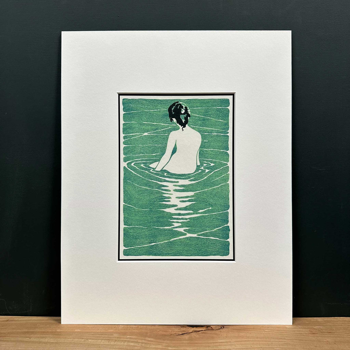 At The Hot Spring, after Narumi, Japan inspired print of female nude seated in water. Shown in 11" x 14" mount on shelf.