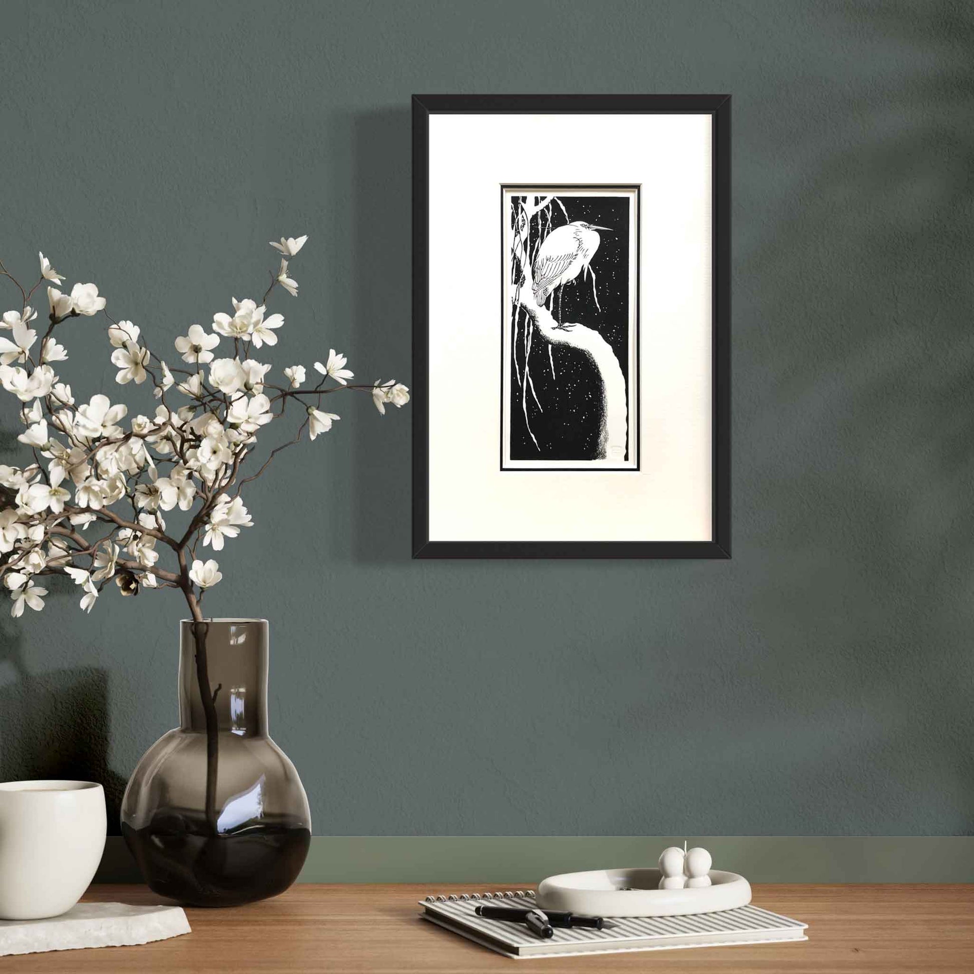 Egret on a Snow-Covered Branch, after Koson — framed woodblock print by artist Claire Cameron-Smith, shown on a dark wall for scale.