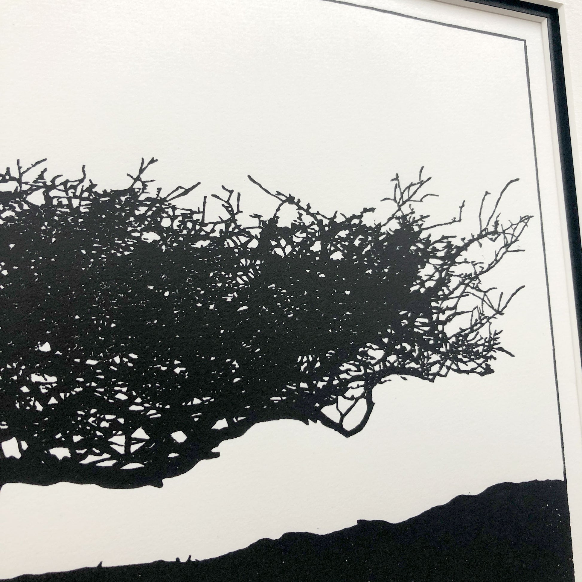 Close-up detail of hand-printed hawthorn tree showing delicate branch structure and subtle ink variation on cream paper.